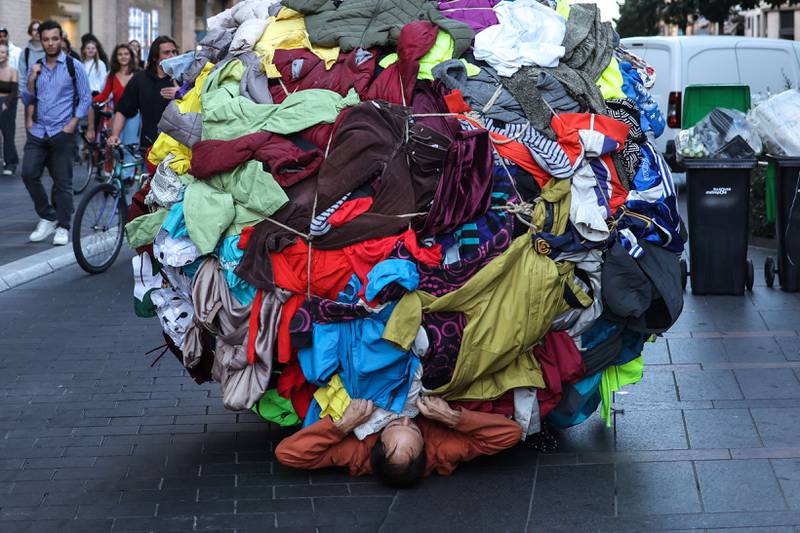Actor and director Dorian Chavez with a ball covered by clothes at a metro station during a performance of 'Sisypolia' – denouncing the absurdity of overconsumption – in Toulouse, south-west France as part of the Biennale des arts vivants de Toulouse. AFP