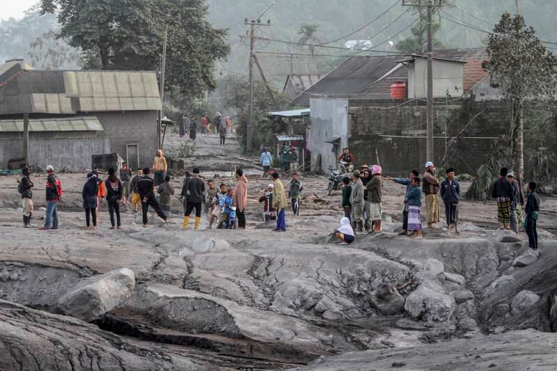 Villagers inspect an area buried in volcanic ash. EPA