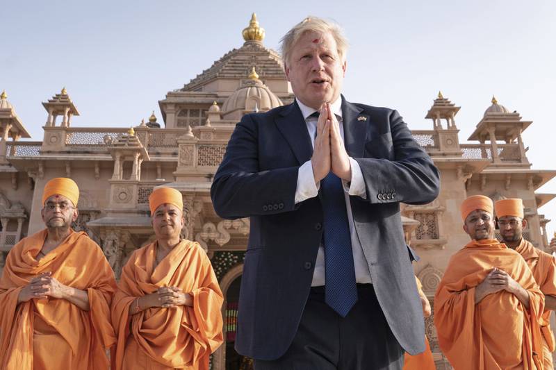British Prime Minister Boris Johnson walks with Hindu holymen at a temple in Ahmedabad during his two-day trip to India. AP