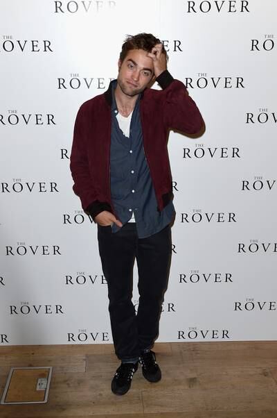 Robert Pattinson, in a burgundy jacket, blue shirt and jeans, attends 'The Rover' photocall in London on August 6, 2014 Getty Images