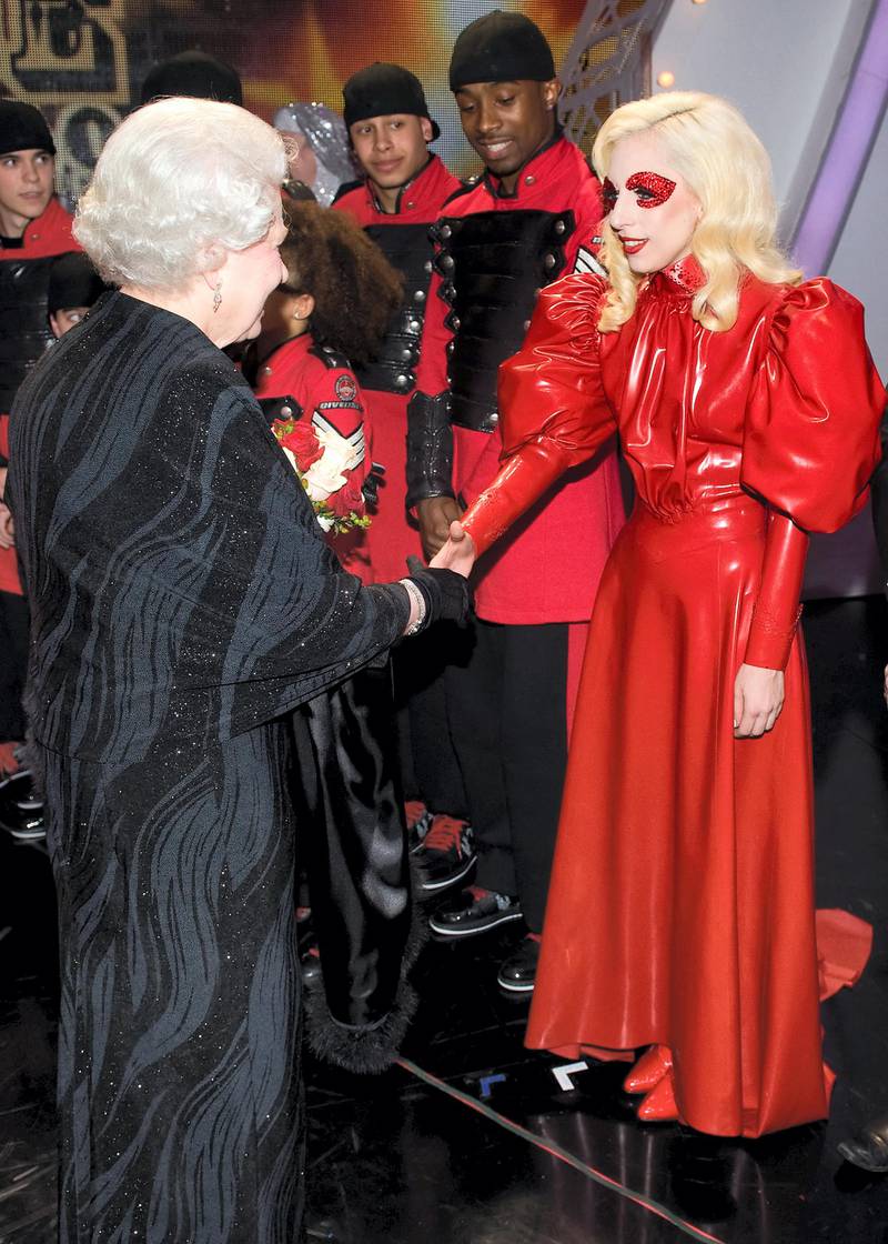 Britain's Queen Elizabeth II (L) meets American singer Lady Gaga (R) following the Royal Variety Performance in Blackpool, England on December 7, 2009. Returning to the town for the first time since 1955, the annual show features a wide range of artists from all aspects of popular entertainment and showbusiness. AFP PHOTO/Leon Neal/POOL (Photo by LEON NEAL / AFP)