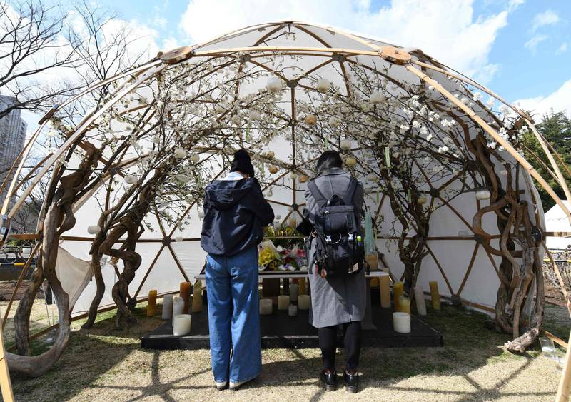 People pray at the altar for the victims of the 2011 Great East Japan earthquake at a park in Tokyo, Japan, March 11, 2018. Japan marked the seventh anniversary of a deadly earthquake, tsunami and nuclear disaster that devastated its northeastern coast and left about about 18,500 people dead or missing. Toshifumi Kitamura / AFP