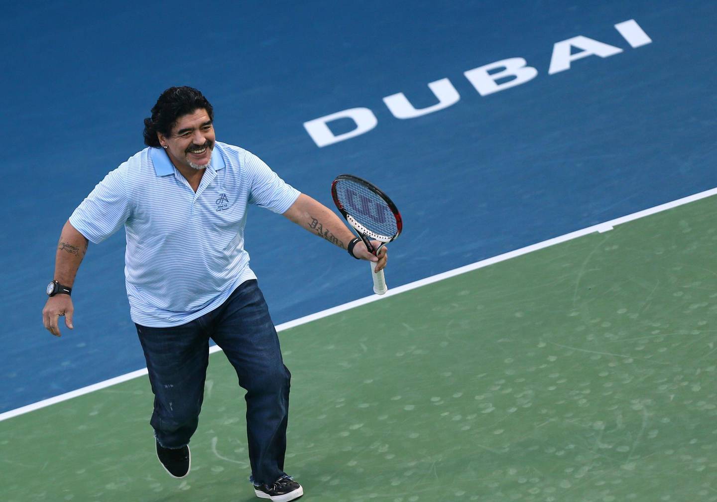 Argentina's football legend Diego Maradona runs as he plays against his compatriot tennis player Juan Martin Del Potro during a show following Del Potro's victory against India's Somdev Devvarman during the ATP Dubai Open tennis tournament in the Gulf emirate on February 27, 2013.  AFP PHOTO/MARWAN NAAMANI (Photo by MARWAN NAAMANI / AFP)