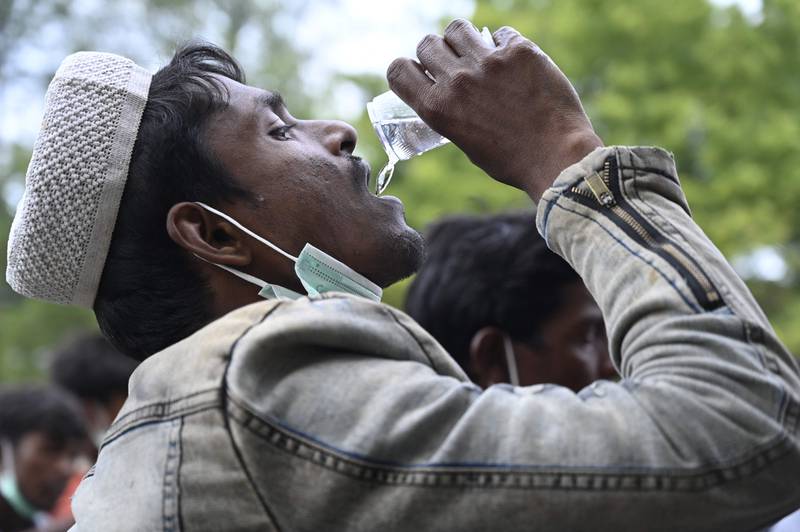 A Rohingya refugee quenches his thirst after reaching Krueng Raya, Indonesia, by boat on December 25. AFP