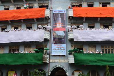 Students wave Indian flags and surround a banner showing the Chandrayaan-3 spacecraft in Ahmedabad on August 12, 2023. AFP