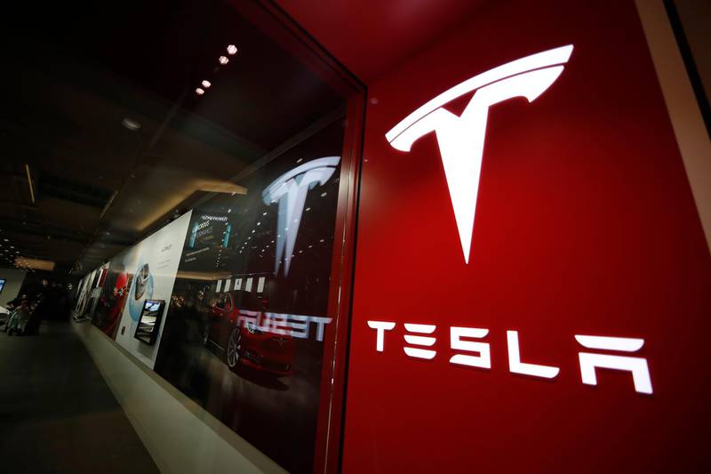 FILE - In this Feb. 9, 2019, file photo, a sign bearing the company logo stands outside a Tesla store in Cherry Creek Mall in Denver. U.S. safety regulators are continuing their investigation into complaints that Teslaâ€™s giant touch screens can fail and cause the cars to lose the rear camera display and other functions. A preliminary investigation was opened in June 2020 covering 63,000 Model S vehicles. (AP Photo/David Zalubowski, File)