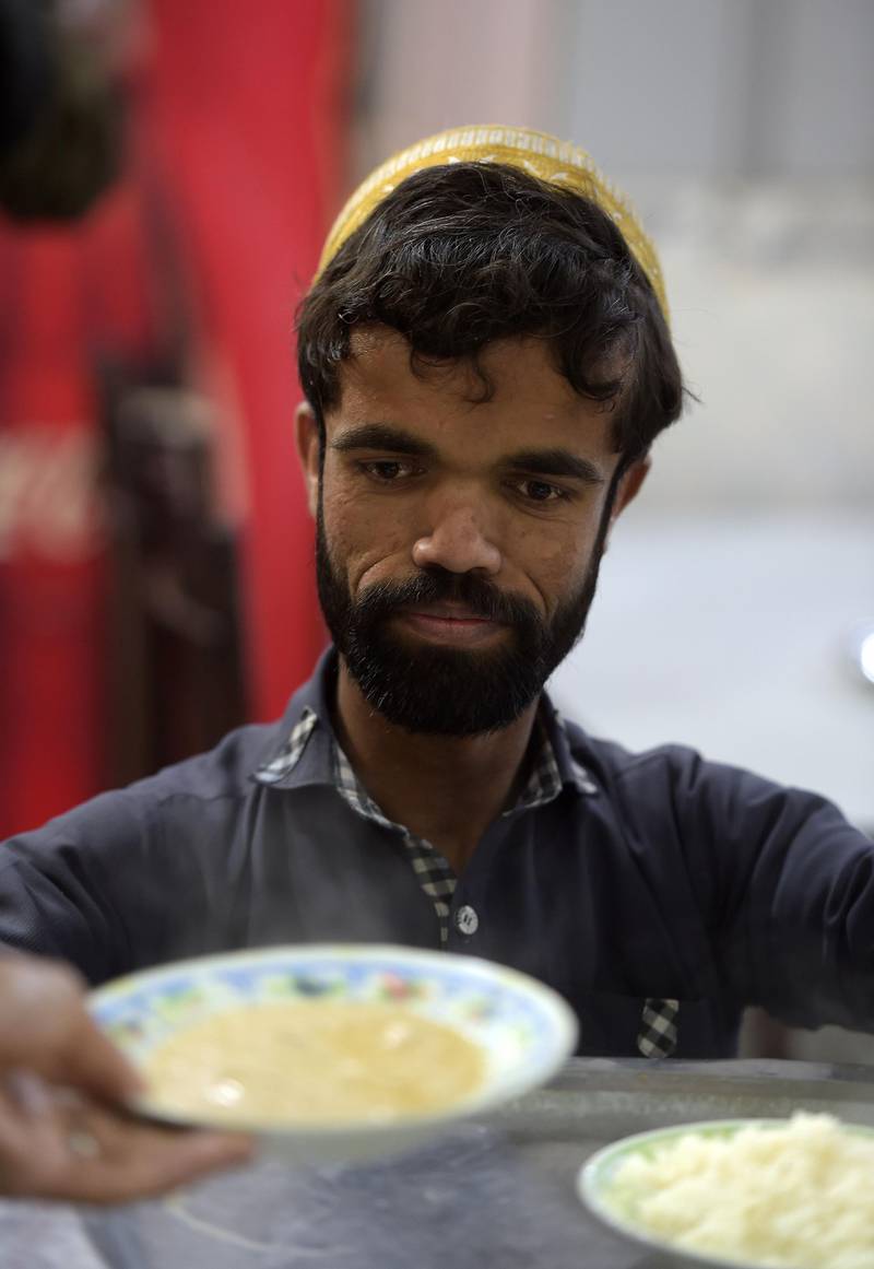 Rozi Khan prepares to serve food to customers at Dilbar Hotel in Rawalpindi. AFP