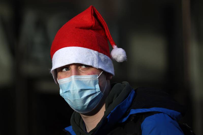 A shopper in a Santa hat and wearing a face covering to combat the spread of the coronavirus walks through Covent Garden in central London. AFP