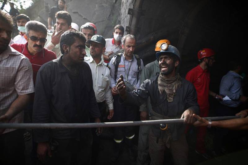 Coal miners and rescue workers gather at the scene following an explosion at a mine in Golestan province in May. Mostafa Hassanzadeh /  AFP