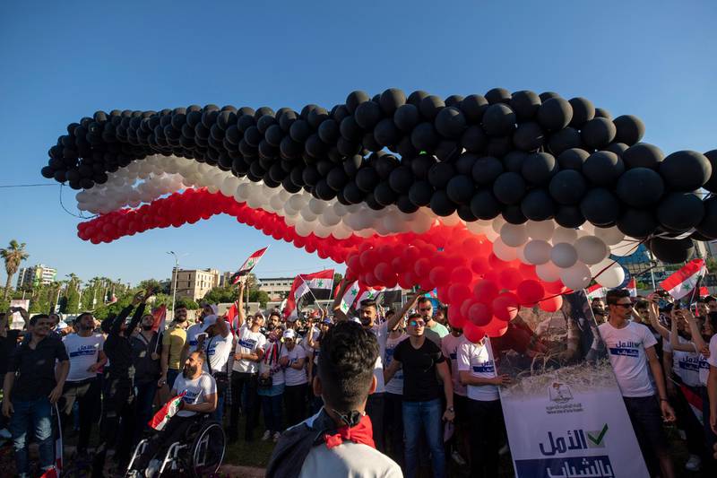 Balloons in the colours of the Syrian flag are released at Umayyad Square. The Assad family has ruled Syria for more than 50 years, including 21 with Bashar Al Assad as president. AP Photo