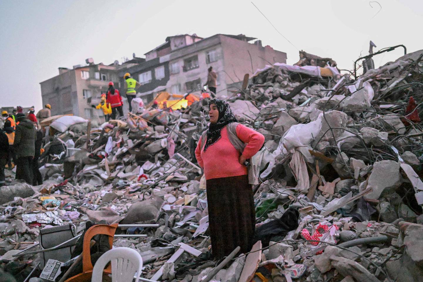 A survivor waits for rescuers to find her relatives trapped under the rubble, in Hatay, Turkey. AFP