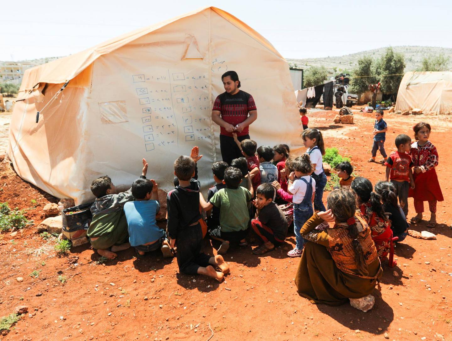 Children attend a class conducted by Muheeb al-Essa, 27, a teacher at a camp for internally displaced people in northern Idlib, Syria, June 10, 2021. Picture taken June 10, 2021. REUTERS/Khalil Ashawi