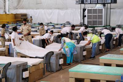 Workers prepare beds at a makeshift Covid-19 ward set up at Radha Soami Satsang Beas in south Delhi. Bloomberg