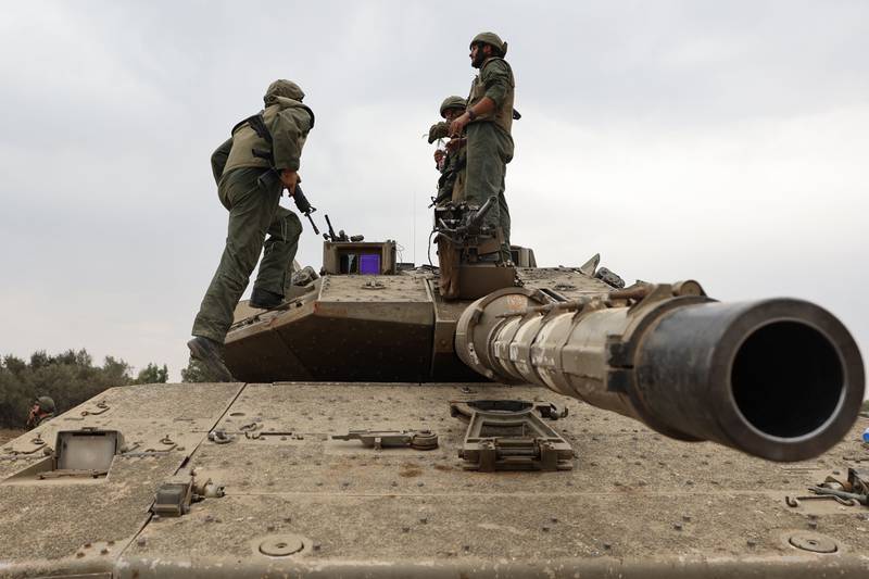 Israeli army soldiers are positioned with their Merkava tanks near the border with the Gaza Strip. AFP