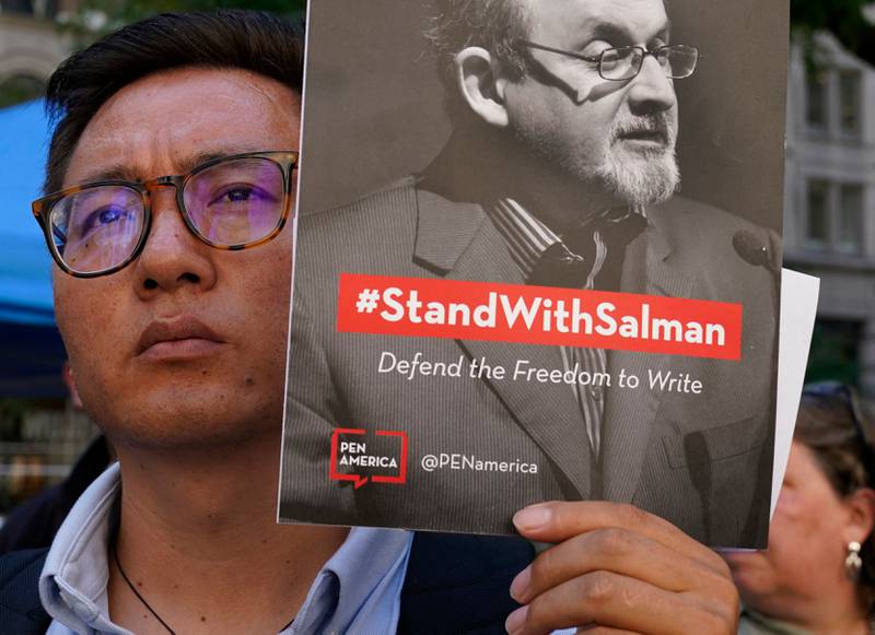 A man holds a sign that reads: #StandWithSalman. AFP