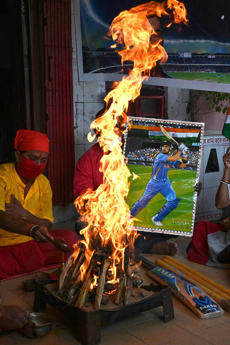 Fans in Kolkata hold a placard with a picture of India captain Virat Kohli as they perform rituals ahead of their T20 World Cup match against Pakistan in Duba. AFP