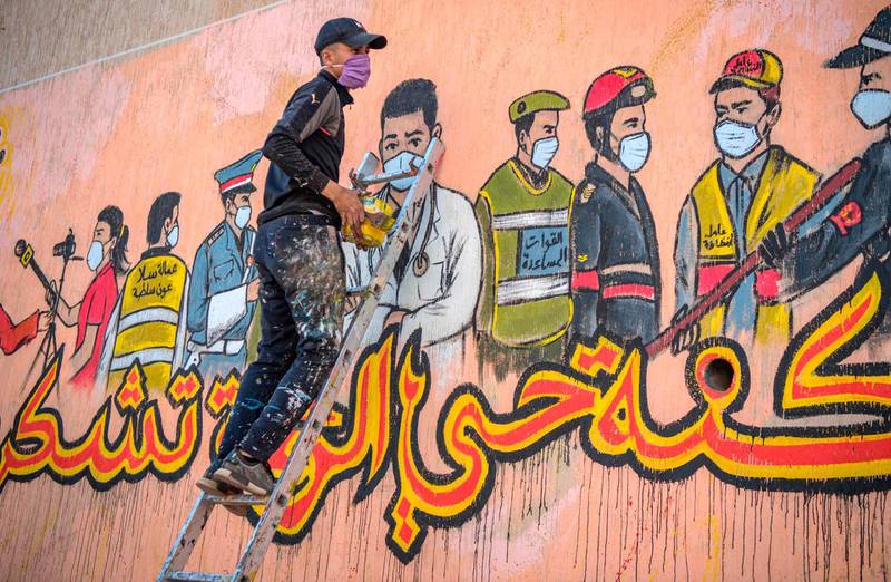 A Moroccan artist works on a mural thanking essential workers, in the city of Sale north of the capital.  AFP