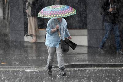 Pedestrians hold umbrellas as they walk in heavy rain in Sydney's central business district, New South Wales, Australia.  EPA