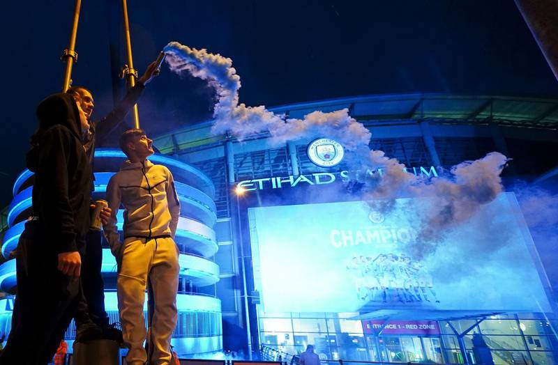 Manchester City supporters celebrate outside the Etihad Stadium. AP
