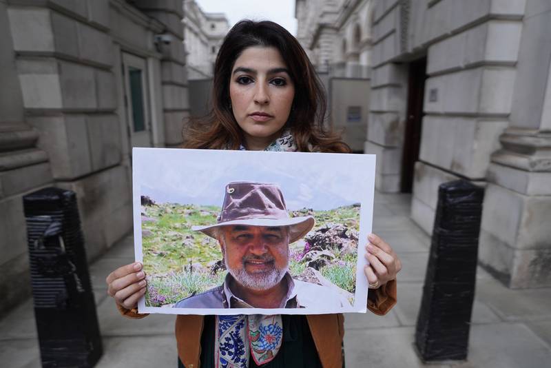 Roxanne Tahbaz holds a picture of her father Morad Tahbaz, who is jailed in Iran, at a protest outside the Foreign Office in London. PA