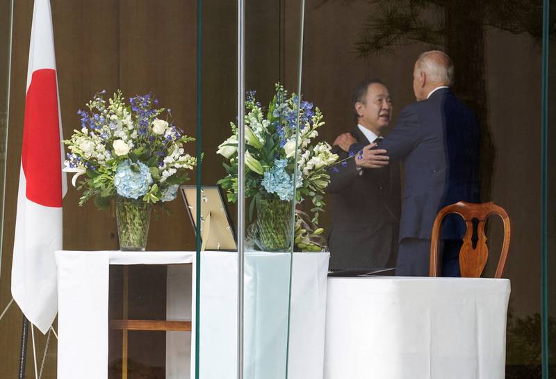 Mr Biden is embraced by Mr Koji. Reuters