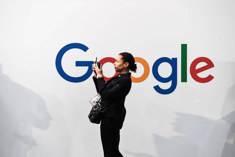 (FILES) In this file photo taken on May 16, 2019 a woman takes a picture with two smartphones in front of the logo of the US multinational technology and Internet-related services company Google as he visits the Vivatech startups and innovation fair, in Paris. Google parent Alphabet's stock price leapt July 25, 2019, after reporting stronger-than-expected results in a quarterly update coming amid growing scrutiny of technology firms by antitrust regulators. / AFP / ALAIN JOCARD
