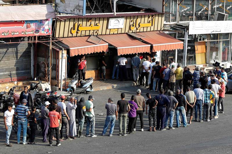 People queue at a bakery to buy bread in Lebanon's southern city of Sidon, as fuel and wheat are particularly scarce across the nation. AFP