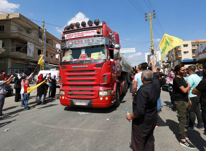 People wave Hezbollah flags as a convoy of tankers carrying Iranian fuel oil arrive in Baalbeck, Lebanon. Reuters