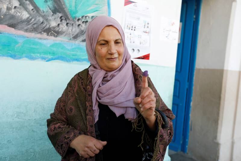 A woman shows the ink on her finger after voting at a polling station. Reuters