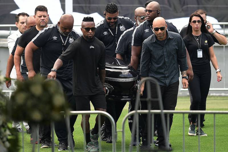 Mourners carry the casket of Pele into the Urbano Caldeira Stadium in Santos. AFP