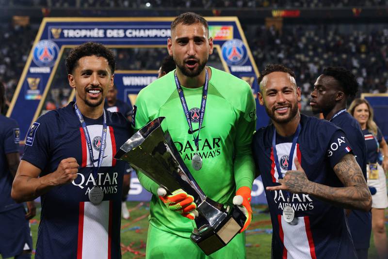 PSG goalkeeper Gianluigi Donnarumma holds the trophy as he poses alongside Marquinhos and Neymar after winning the Trophee des Champions. AFP