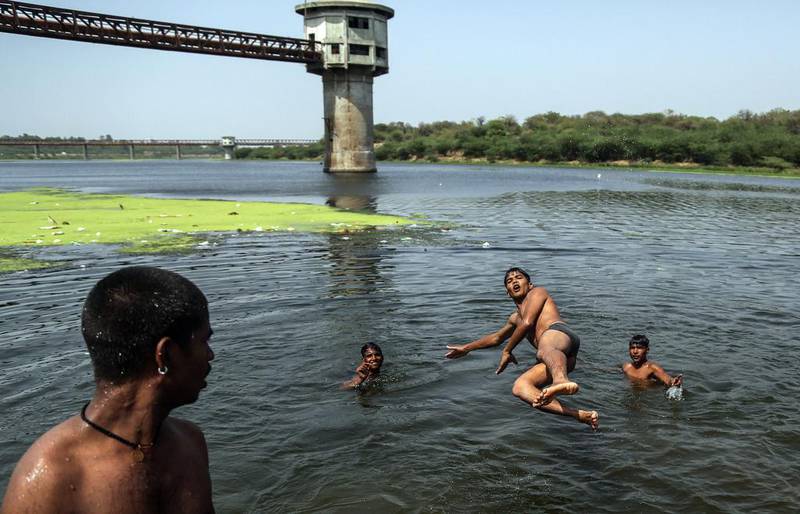 Youths have fun in the Sabarmati river as they refresh themselves from heat on a hot afternoon in Ahmedabad.  Divyakant Solanki / EPA
