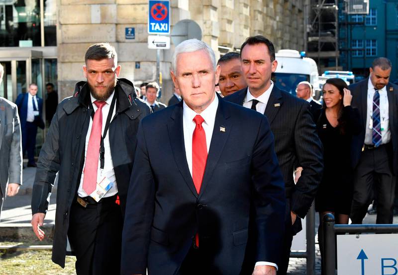 US Vice President Mike Pence (C) crosses a street to give a statement in front of the Bayerischer Hof hotel at the 55th Munich Security Conference in Munich, southern Germany, on February 16, 2019. The 2019 edition of the Munich Security Conference (MSC) takes place from February 15 to 17, 2019.  / AFP / THOMAS KIENZLE
