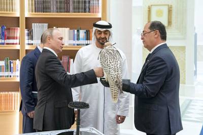 ABU DHABI, UNITED ARAB EMIRATES - October 15, 2019: HH Sheikh Mohamed bin Zayed Al Nahyan, Crown Prince of Abu Dhabi and Deputy Supreme Commander of the UAE Armed Forces (C) and HE Vladimir Putin Vladimirovich, President of Russia (L), exchange gifts during a state visit at Qasr Al Watan. ( Mohamed Al Hammadi / Ministry of Presidential Affairs )---