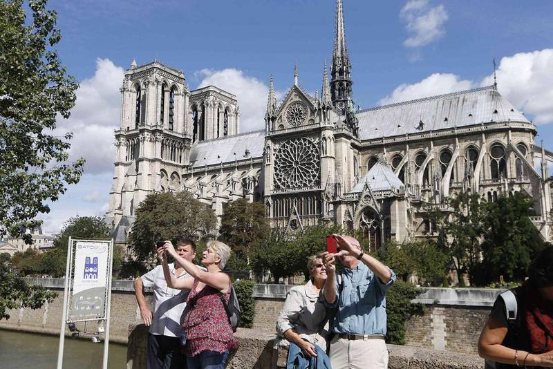 3rd: Paris. Tourists take selfies outside Notre Dame Cathedral in Paris. The Notre Dame Cathedral greets some 13 million tourists a year according to its official website. The cathedral, with its construction dating from 1163, is an important example of French Gothic architecture, sculpture and stained glass. Charles Platiau / Reuters