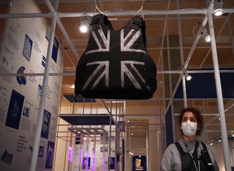 A museum employee poses next to a customised stab-proof vest, designed by street artist Banksy and worn by British musician Stormzy during his performance at the Glastonbury Festival in 2019, at the Design Museum in London. EPA