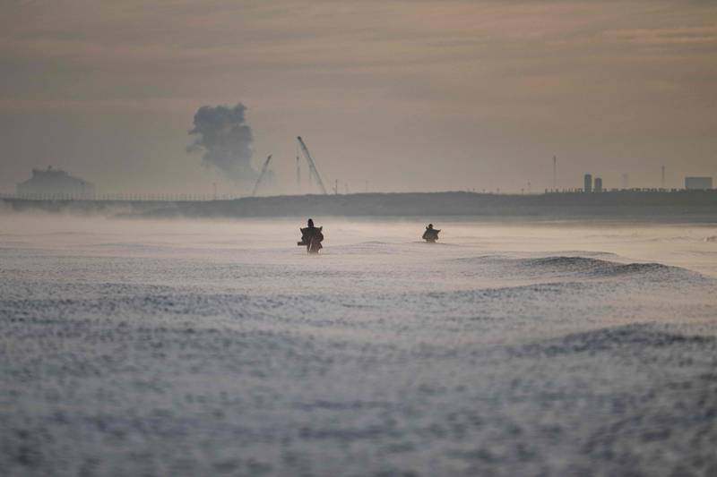 Shrimp fishermen are seen in the waters, with the Gravelines Nuclear Power Station in background, near Dunkirk, northern France. AFP
