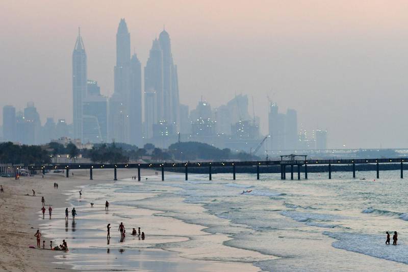 A picture taken on September 26, 2018 shows people on the beach in the United Arab Emirate of Dubai. / AFP / GIUSEPPE CACACE
