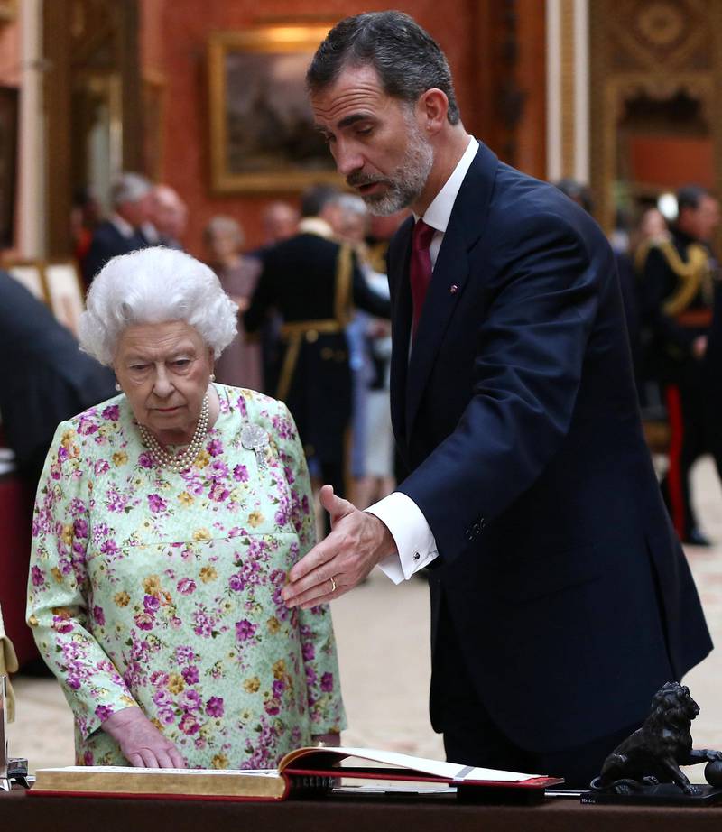King Felipe VI (R) and Queen Elizabeth II look at a display of Spanish items from the Royal Collection at Buckingham Palace. Neil Hall.