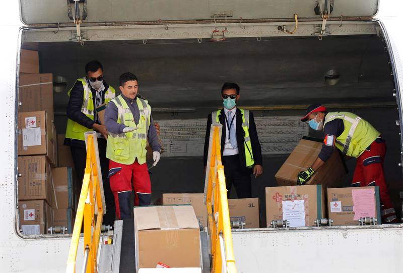 Workers unload medical supplies from China at Houari Boumediene International Airport in Algiers, Algeria, April 15, 2020. The equipment was donated to Algeria amid the ongoing coronavirus pandemic.  EPA