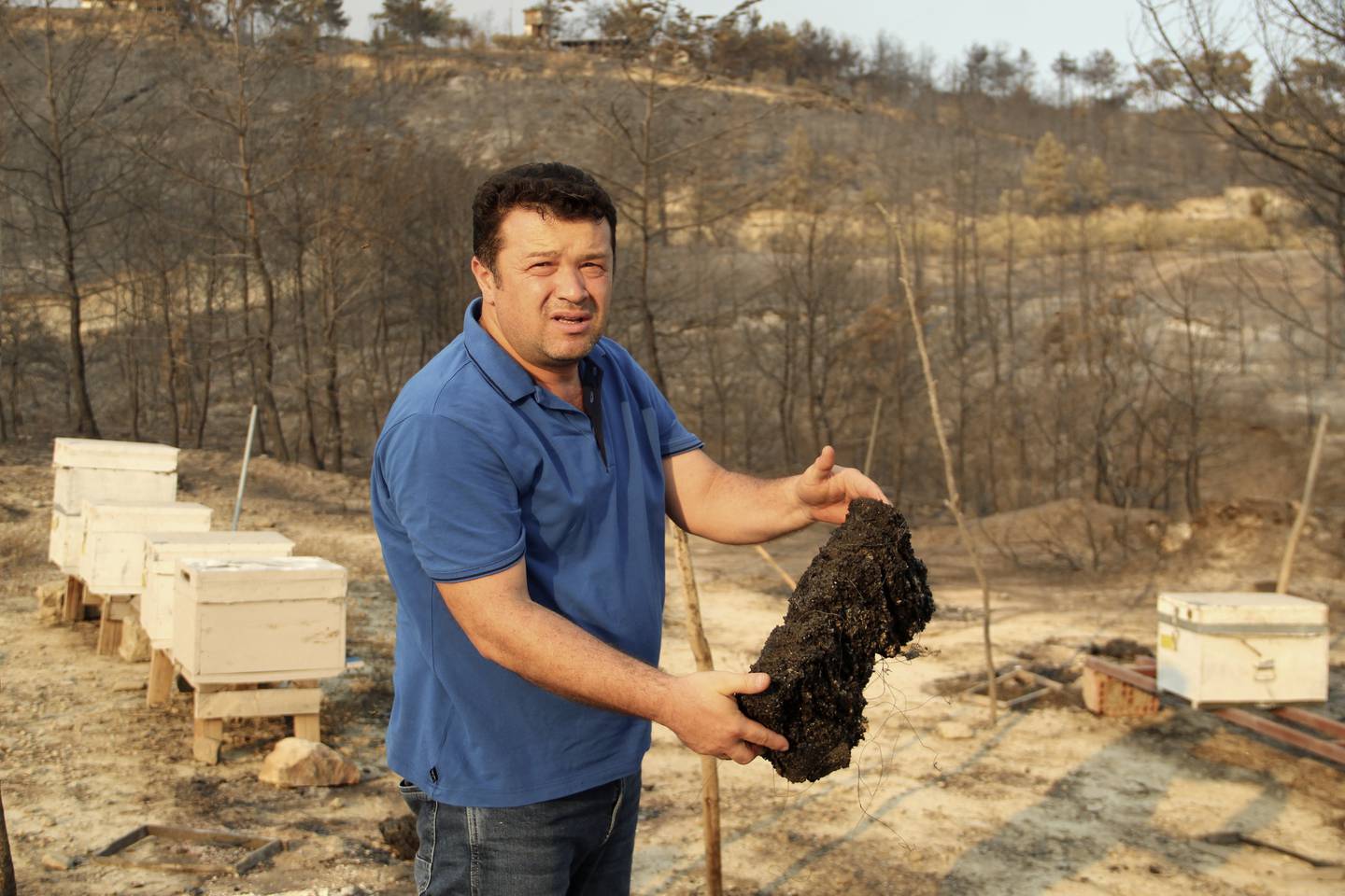 Beekeeper Guven Karagol shows his burnt beehives in Manavgat, Turkey, on August 7. AP