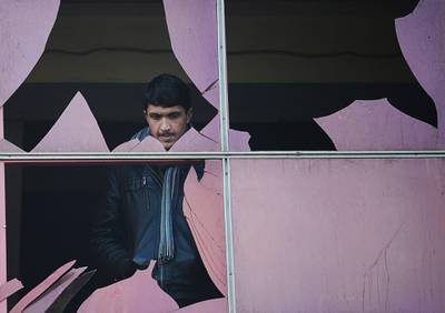A man looks through a broken window at the site of a suicide attack in Kabul. January 26, 2014. Shah Marai / AFP
