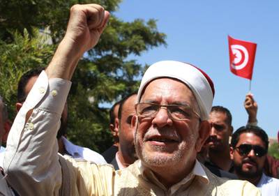 Abdelfattah Mourou (C), Tunisia's interim parliamentary speaker and Islamist-inspired Ennahda Party politician, waves to supporters and journalists after submitting his candidacy for the upcoming early presidential elections at the Independent High Authority for Elections (ISIE), in the capital Tunis on August 9, 2019. Ennahdha Party had announced that Mourou would be their presidential candidate for the first time on August 7, ahead of polls next month. Mourou, 71, was appointed interim parliamentary speaker following the death last month of president Beji Caid Essebsi. The Ennahdha politician had previously served as the deputy speaker, and changed roles after the then parliamentary head Mohamed Ennaceur stepped up as interim president. / AFP / HASNA

