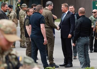 Mr Iohannis is greeted during his visit to Irpin. Reuters