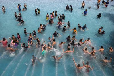People take a dip in a wave pool at a water park in New Delhi. AFP