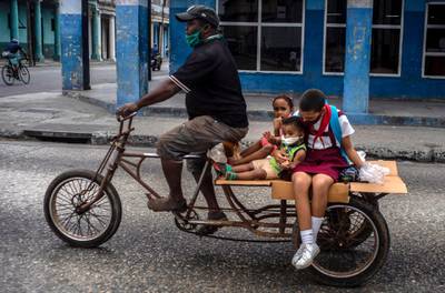 A man transports children on his tricycle, in Havana, Cuba. AP Photo