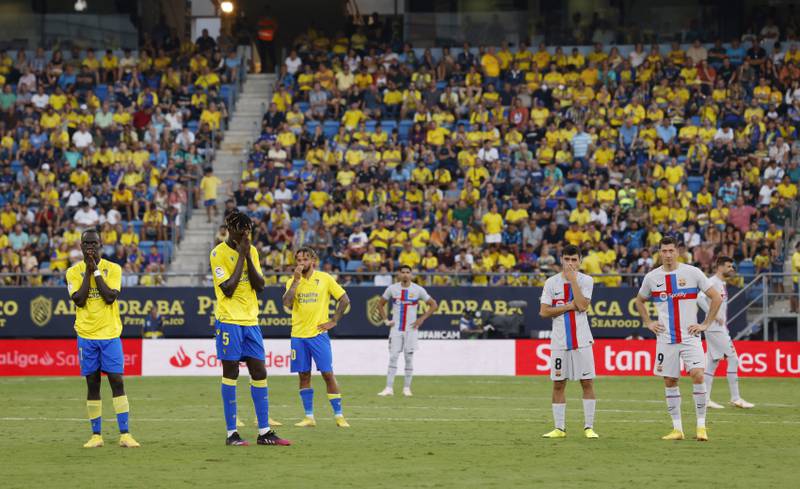 Players wait on the pitch as play is stopped due to a medical emergency in the stands. Reuters