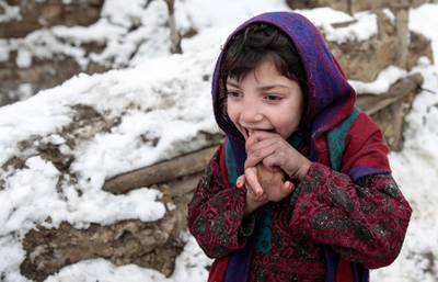 An Afghan child stands in the cold at an Internal Displaced Persons camp in Kabul, Afghanistan.  EPA