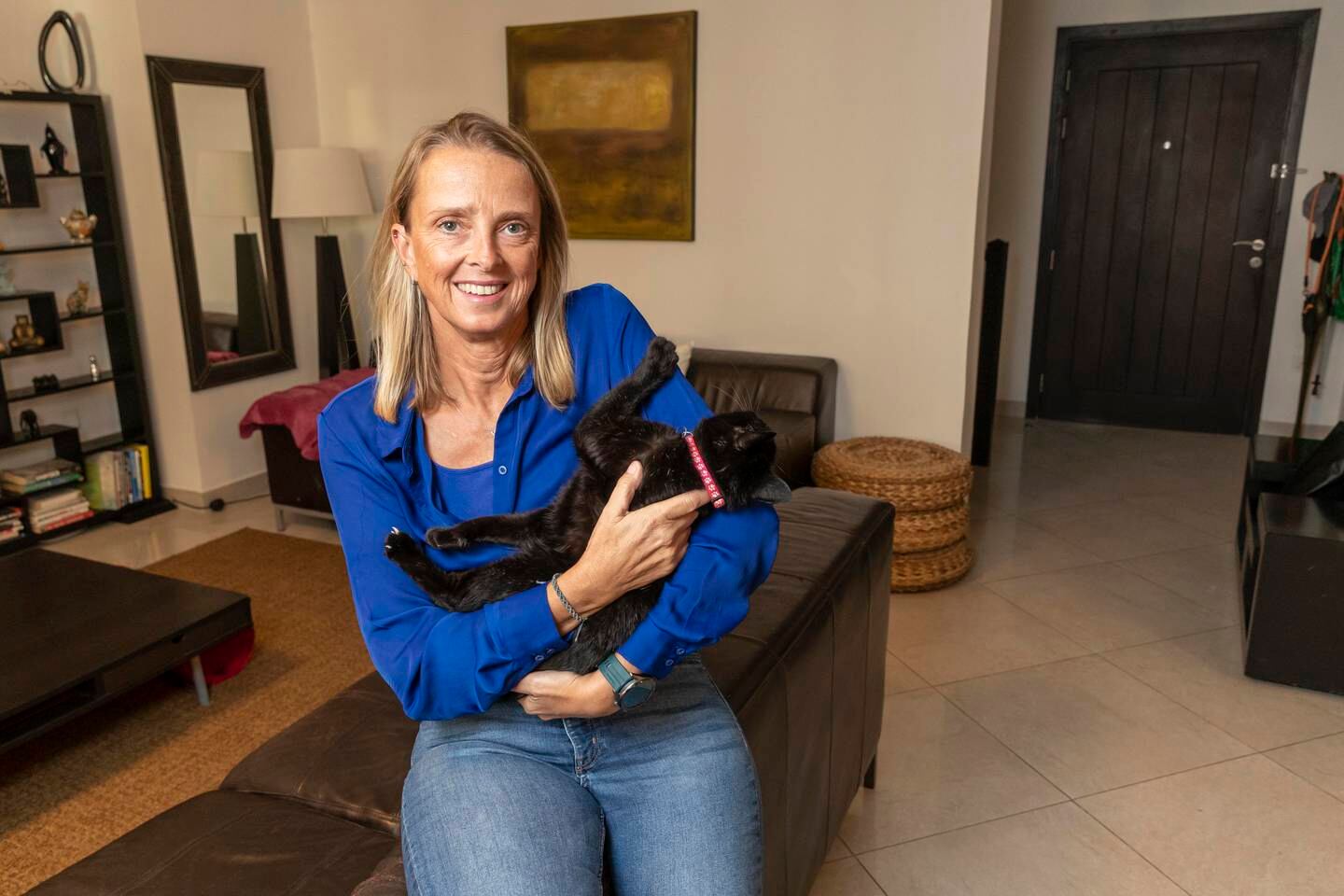 Claire Donnelly with one of her six rescue cats at home in Ras Al Khaimah. Antonie Robertson/The National
