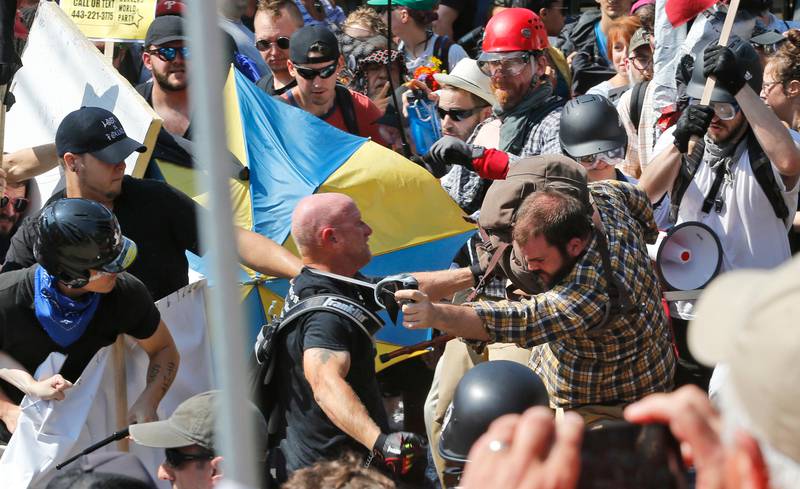 White nationalist demonstrators clash with counter demonstrators at the entrance to Lee Park in Charlottesville. Police dressed in riot gear ordered people to disperse after chaotic violent clashe.  Steve Helber  / AP